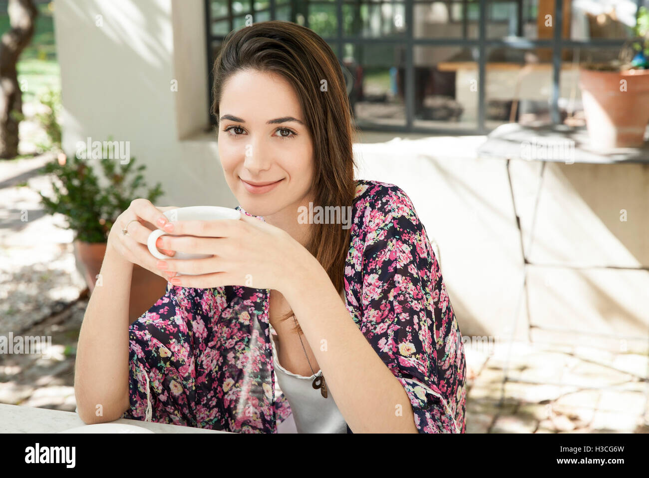 Junge Frau, die Tasse Kaffee im Freien zu genießen Stockfoto