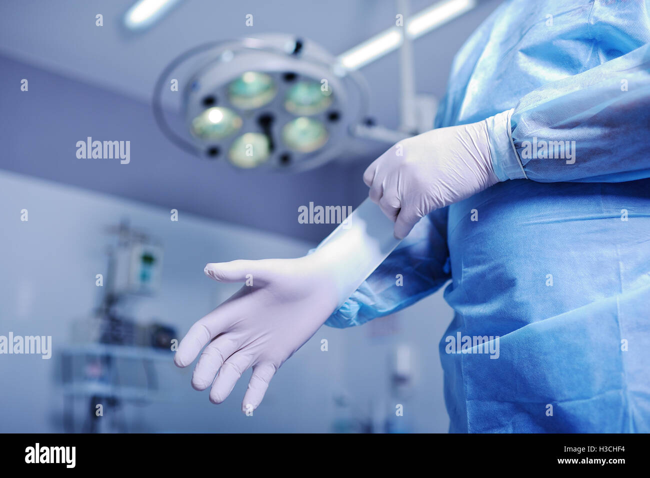 Chirurg Gummihandschuhe vor einer schwierigen Operation aufsetzen Stockfoto