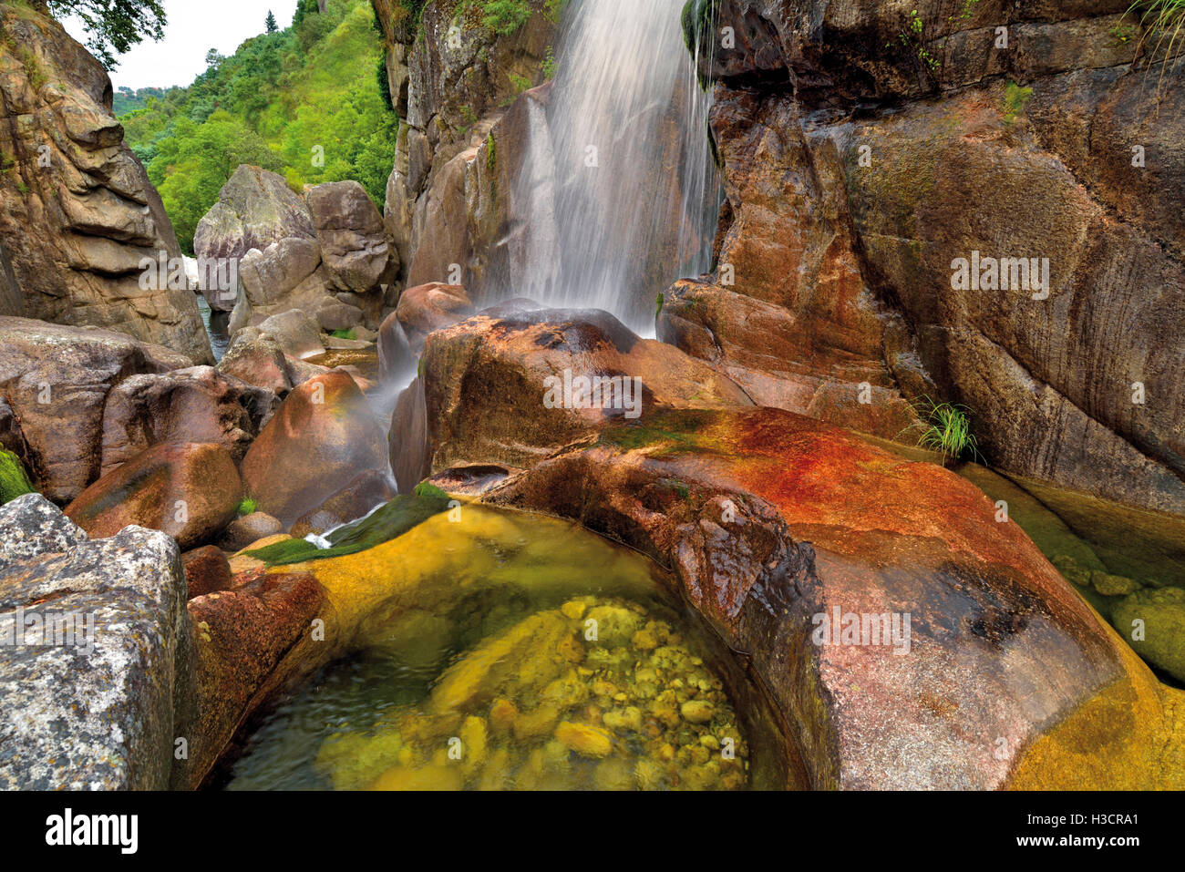 Portugal: Natürlicher Wasserfall mitten im riesigen Felsen in einer kleinen Schlucht laufen Stockfoto