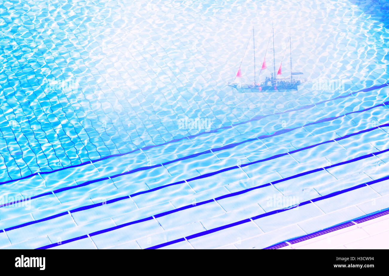 Klares blaues Wasser im Pool im sonnigen Tag mit Träumen von Schiff mit scharlachroten Segel, wie Metapher Stockfoto
