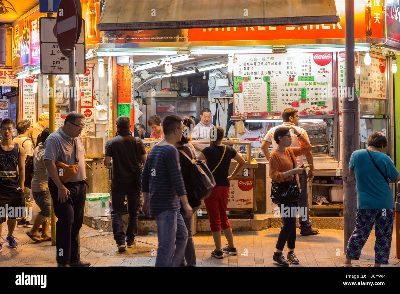Menschen vor ein street Food stall am Rand Prat Ave und Hart Ave in Tsim Sha Tsui, Kowloon, Hong Kong, China in der Nacht. Stockfoto