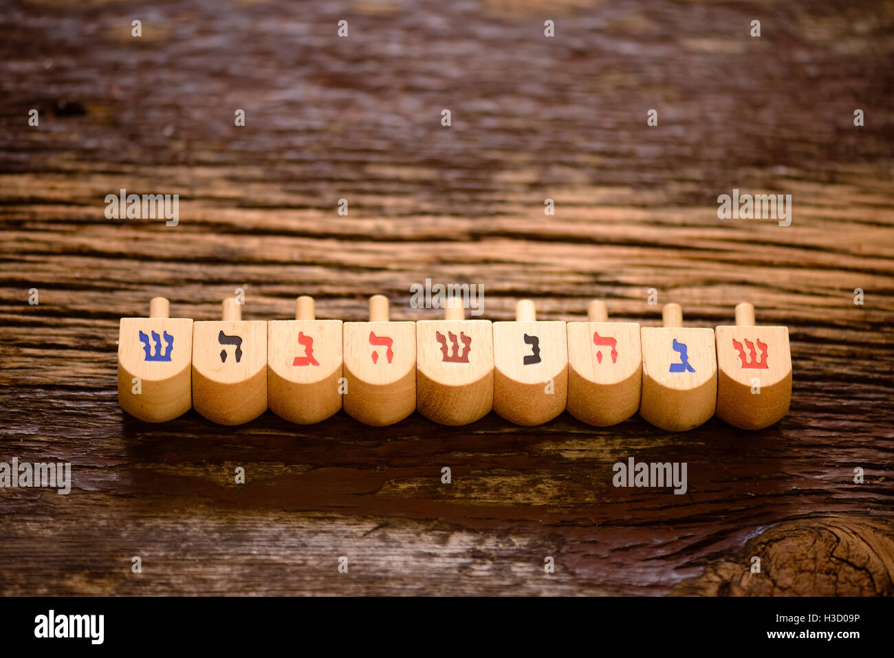 Anordnung der jüdischen Dreidel für Chanukka auf rustikalen Holz gesetzt. Stockfoto