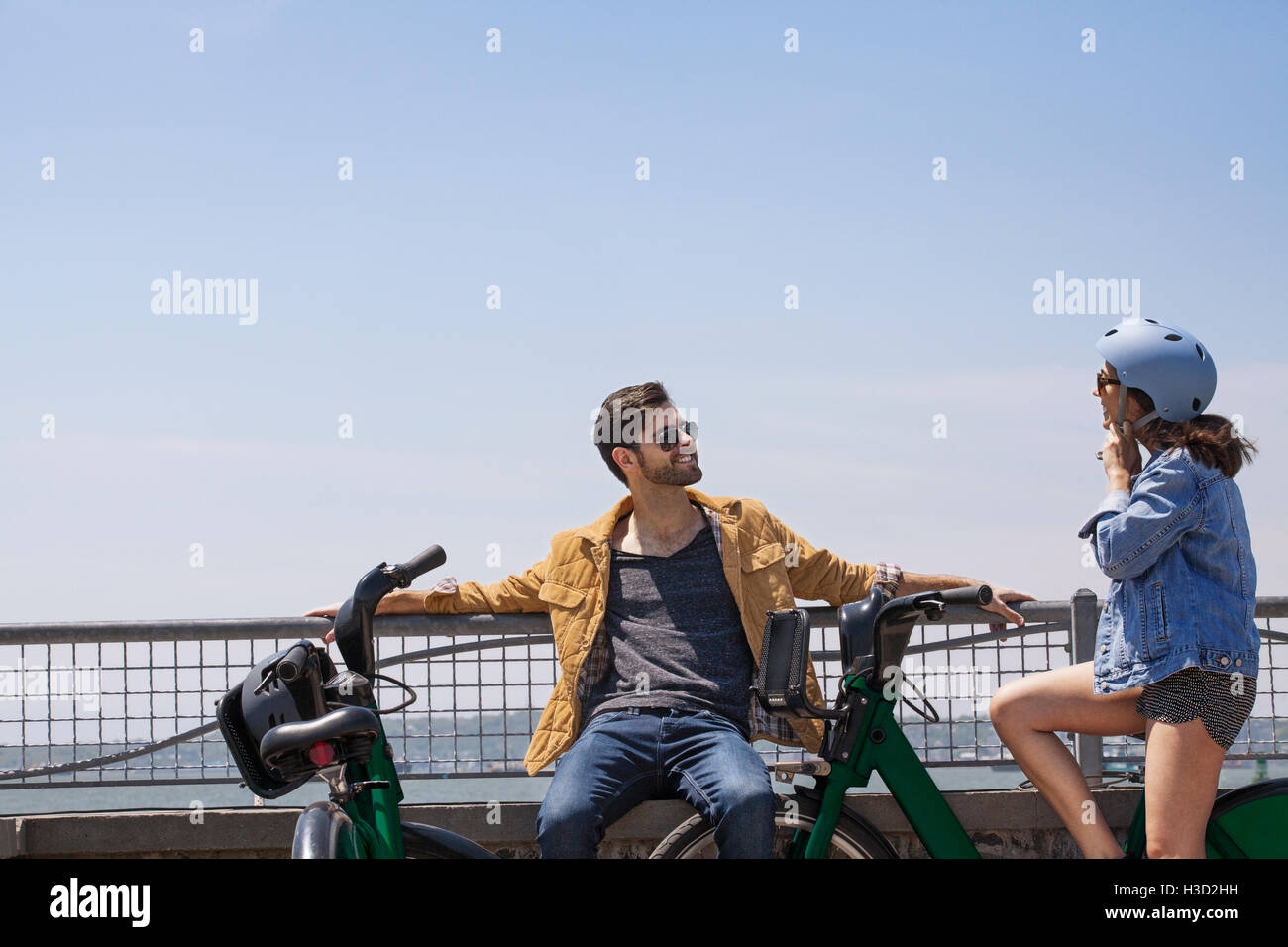 Glückliches Paar sprechen am Aussichtspunkt gegen klaren Himmel Stockfoto