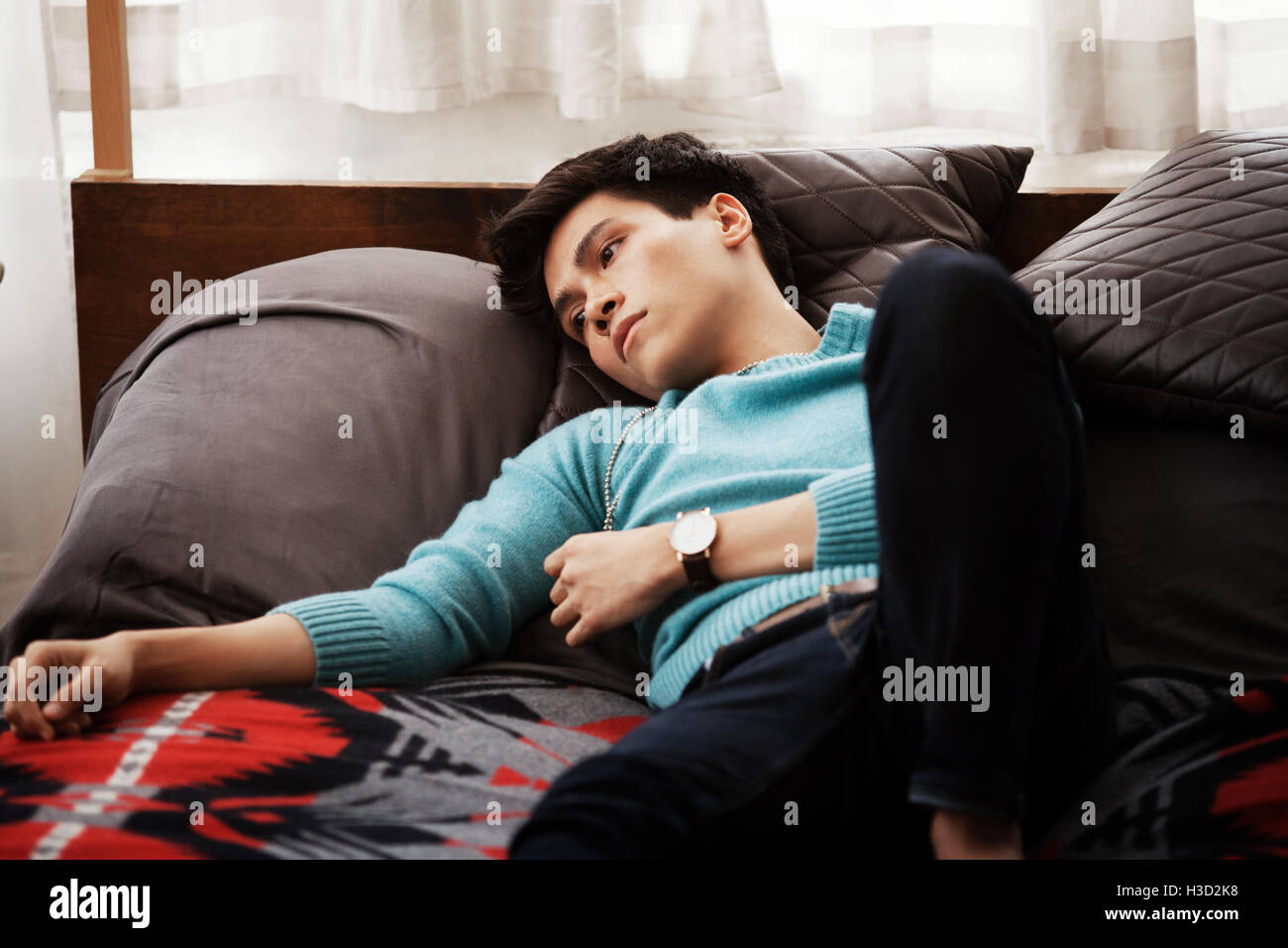 Trauriger Mann liegend im Bett zu Hause Stockfoto