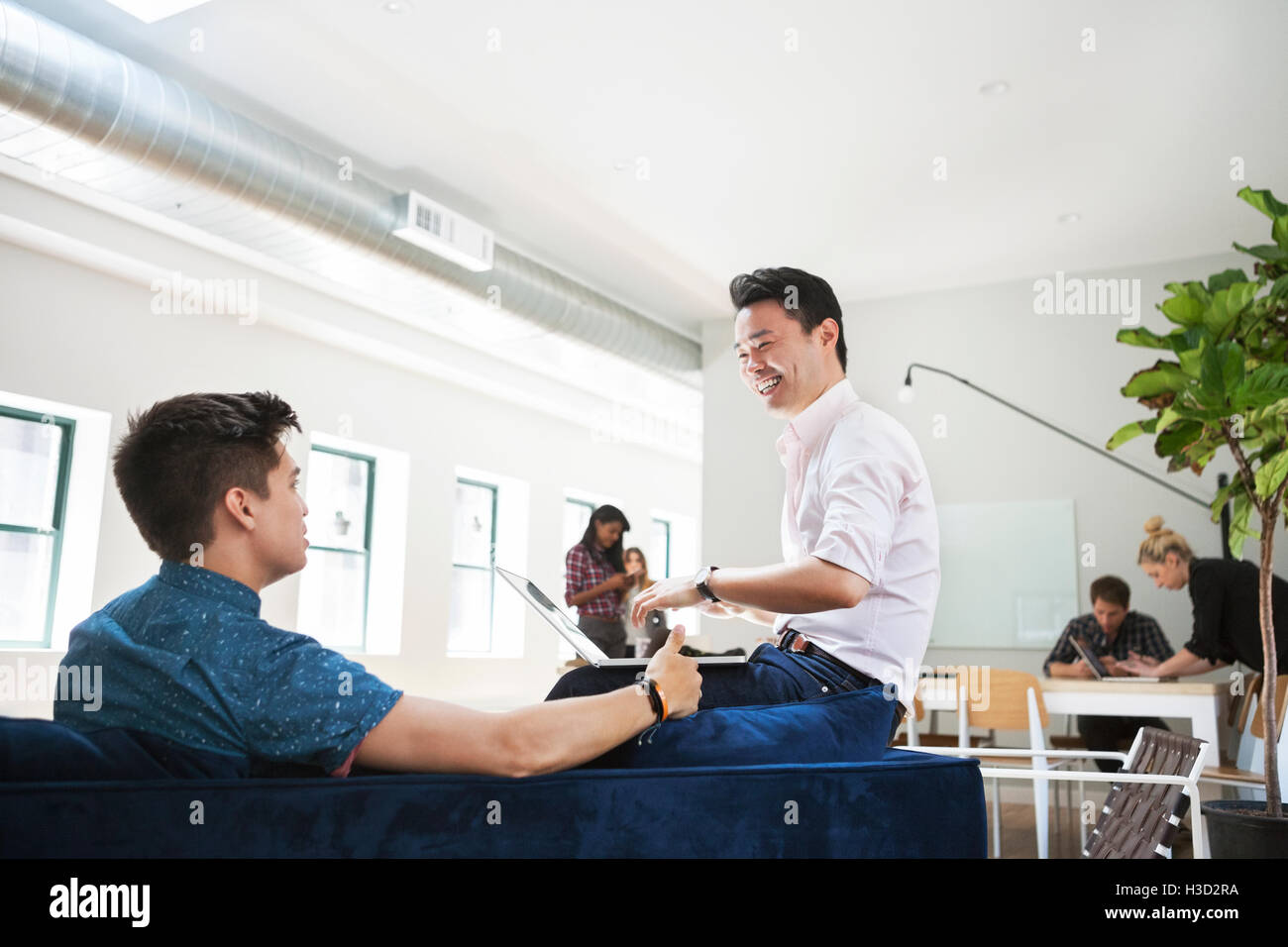 Glücklich Kaufmann diskutieren mit Kollegen in Kreativbüro Stockfoto