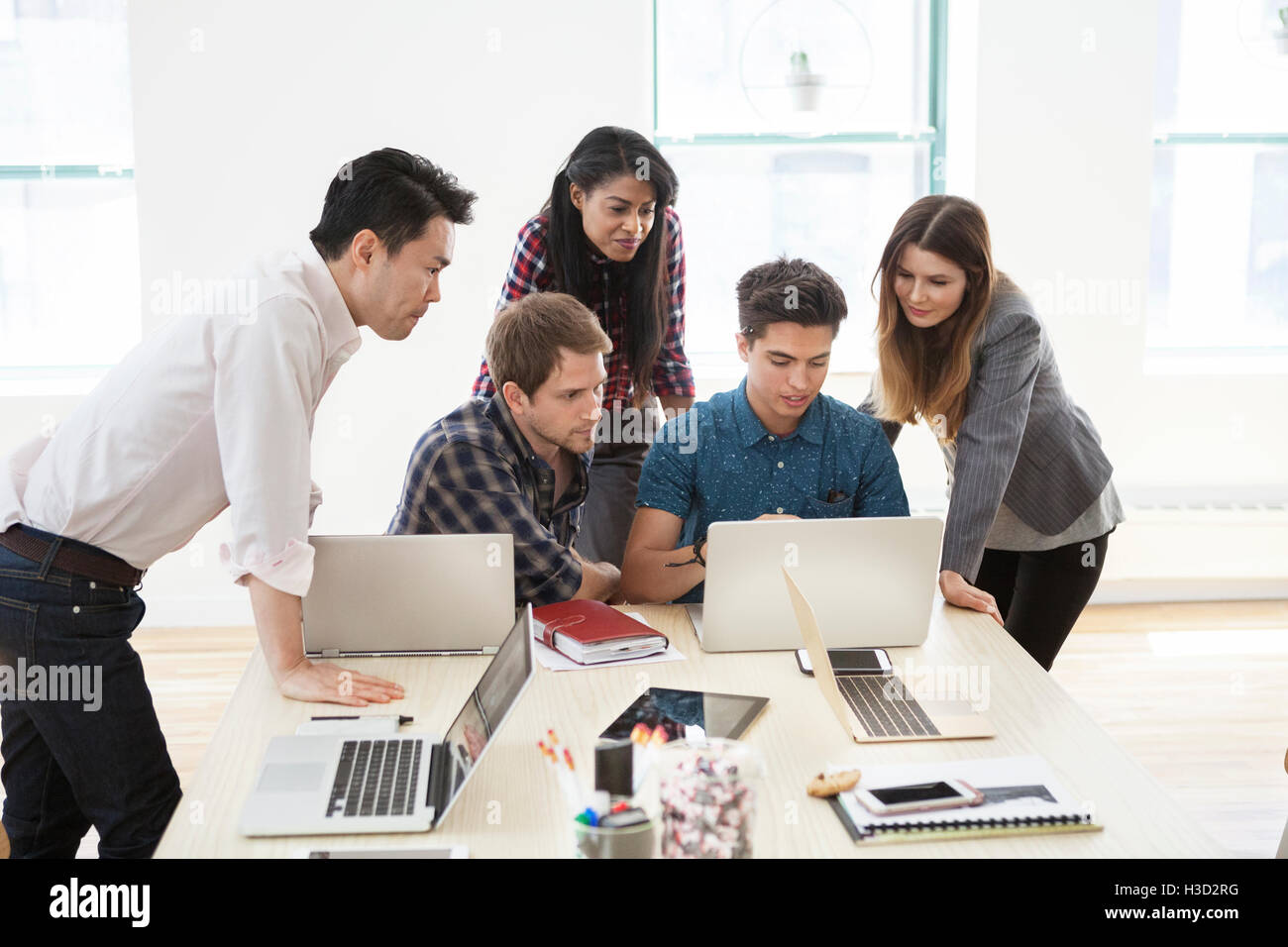 Kreative Geschäftsleute mit Laptop im Konferenzraum Stockfoto