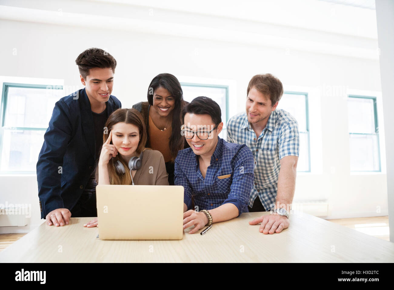 Glücklich Geschäftsleute mit Laptop in Kreativbüro Stockfoto