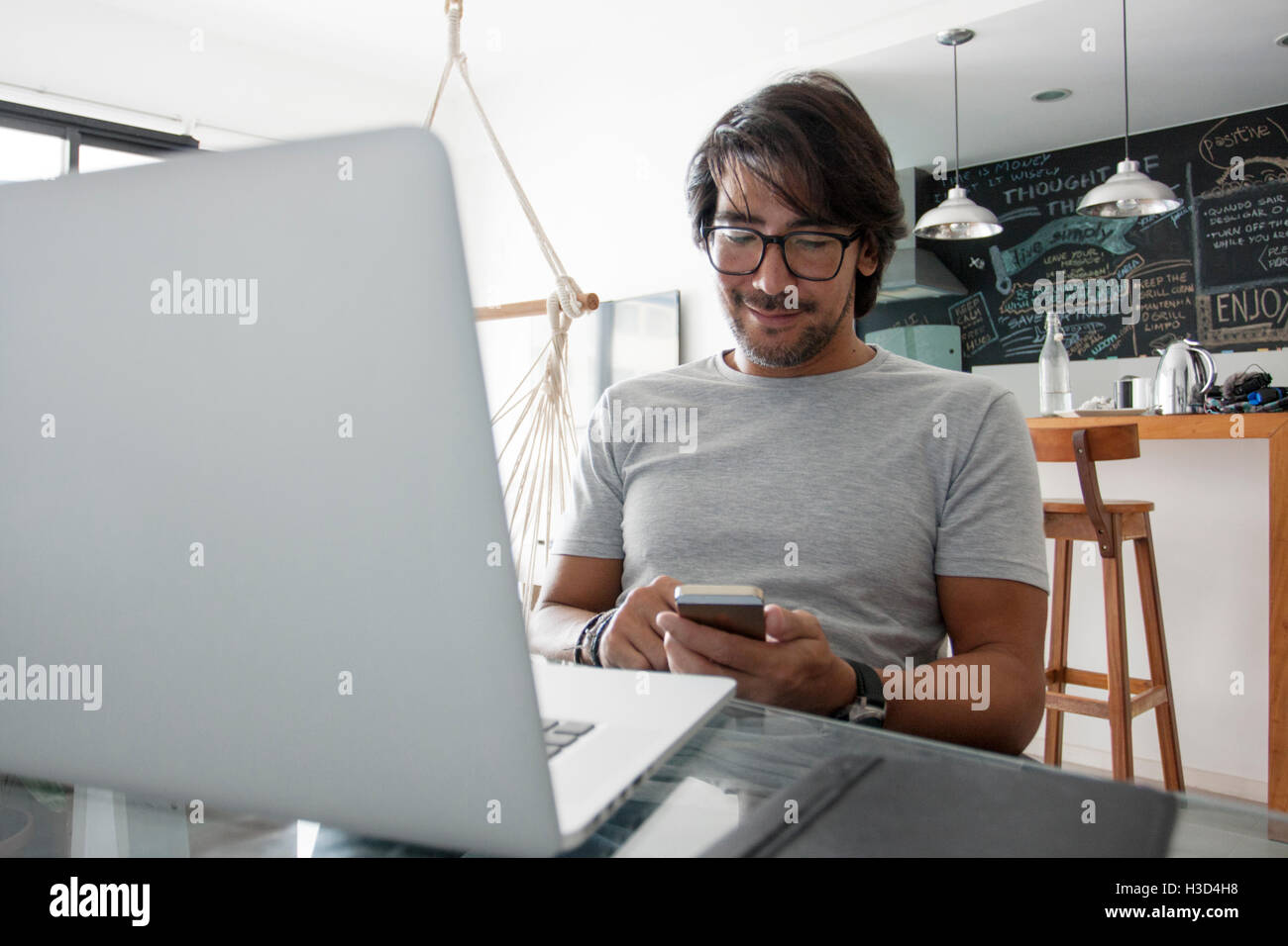 Mann mit Smartphone zu Hause sitzend Stockfoto