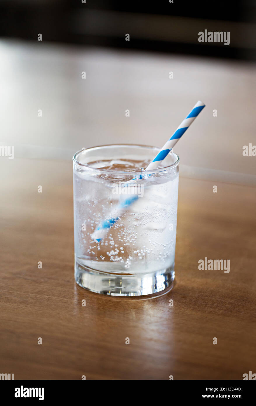 Nahaufnahme von kohlensäurehaltigem Wasser im Glas auf Holztisch zu Hause Stockfoto