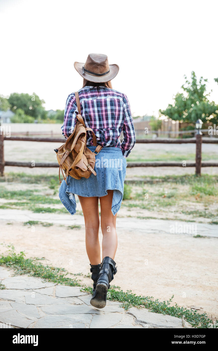 Rückansicht der Frau Cowgirl Hut mit Rucksack zu Fuß auf der ranch Stockfoto