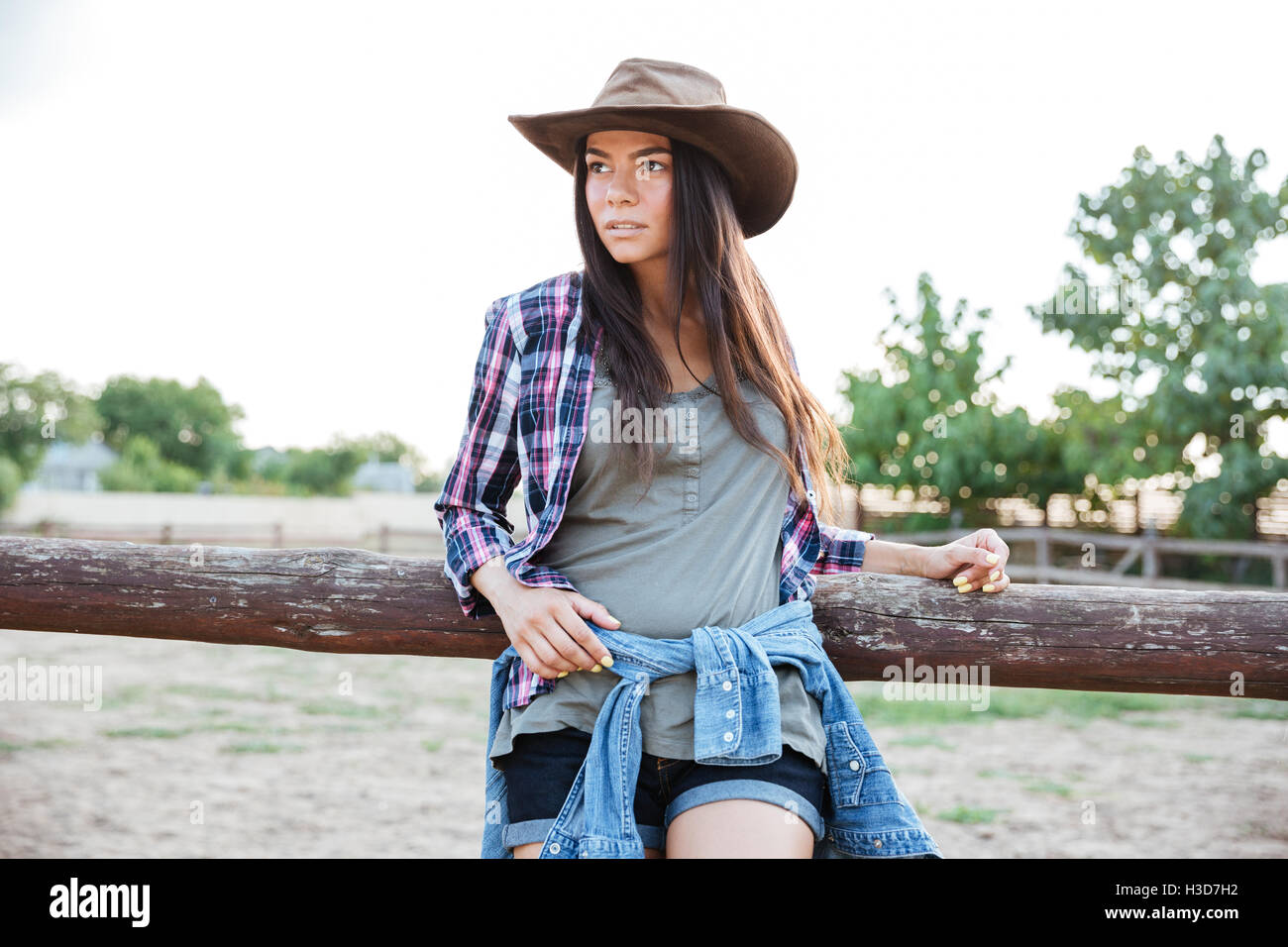 Porträt der schönen jungen Frau Cowgirl Hut und kariertes Hemd Stockfoto
