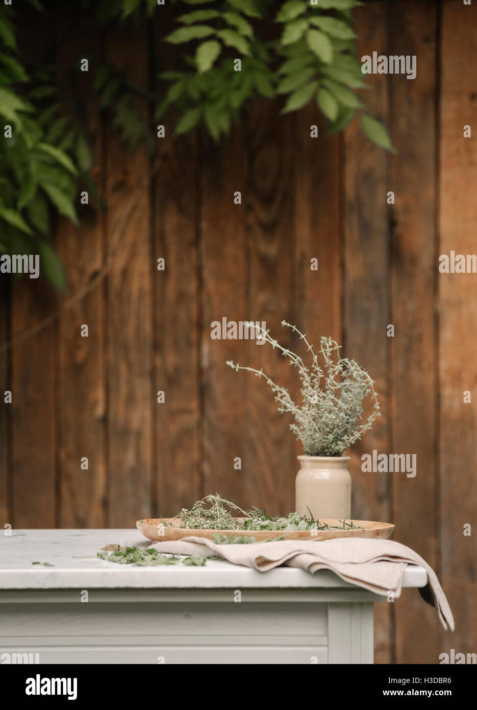 Ein Gartenzaun, einen Tisch und Kräuter in ein Glas. Stockfoto
