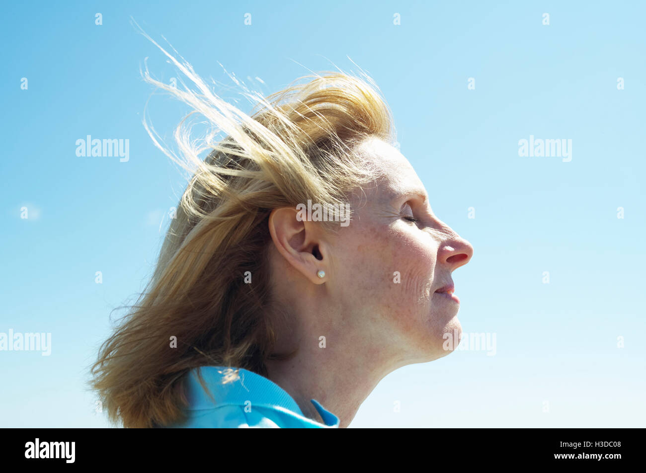 Profil von eine blonde Reife Frau stehend durch den Ozean. Stockfoto