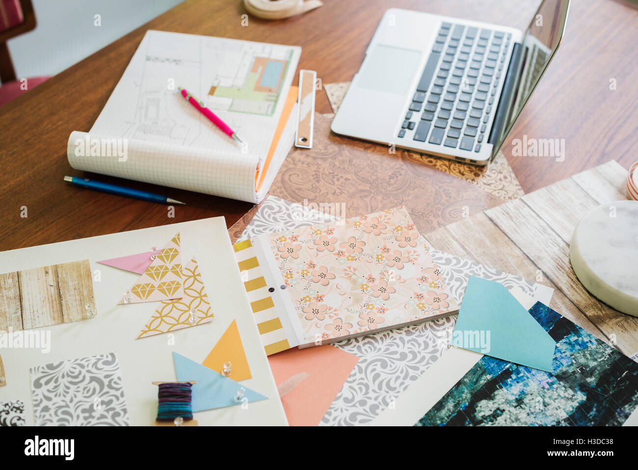 Bastelmaterial, Stoff und Papier, Muster und ein Notebook und Tablet. Stockfoto