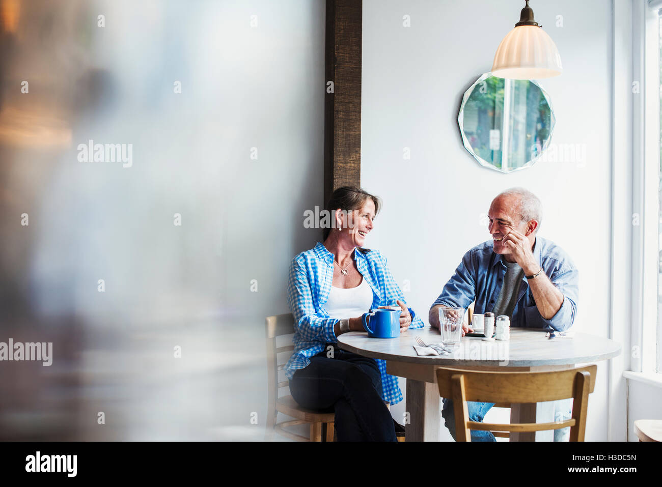 Zwei Menschen sitzen an einem Café-Tisch.  Unscharfen Vordergrund. Stockfoto