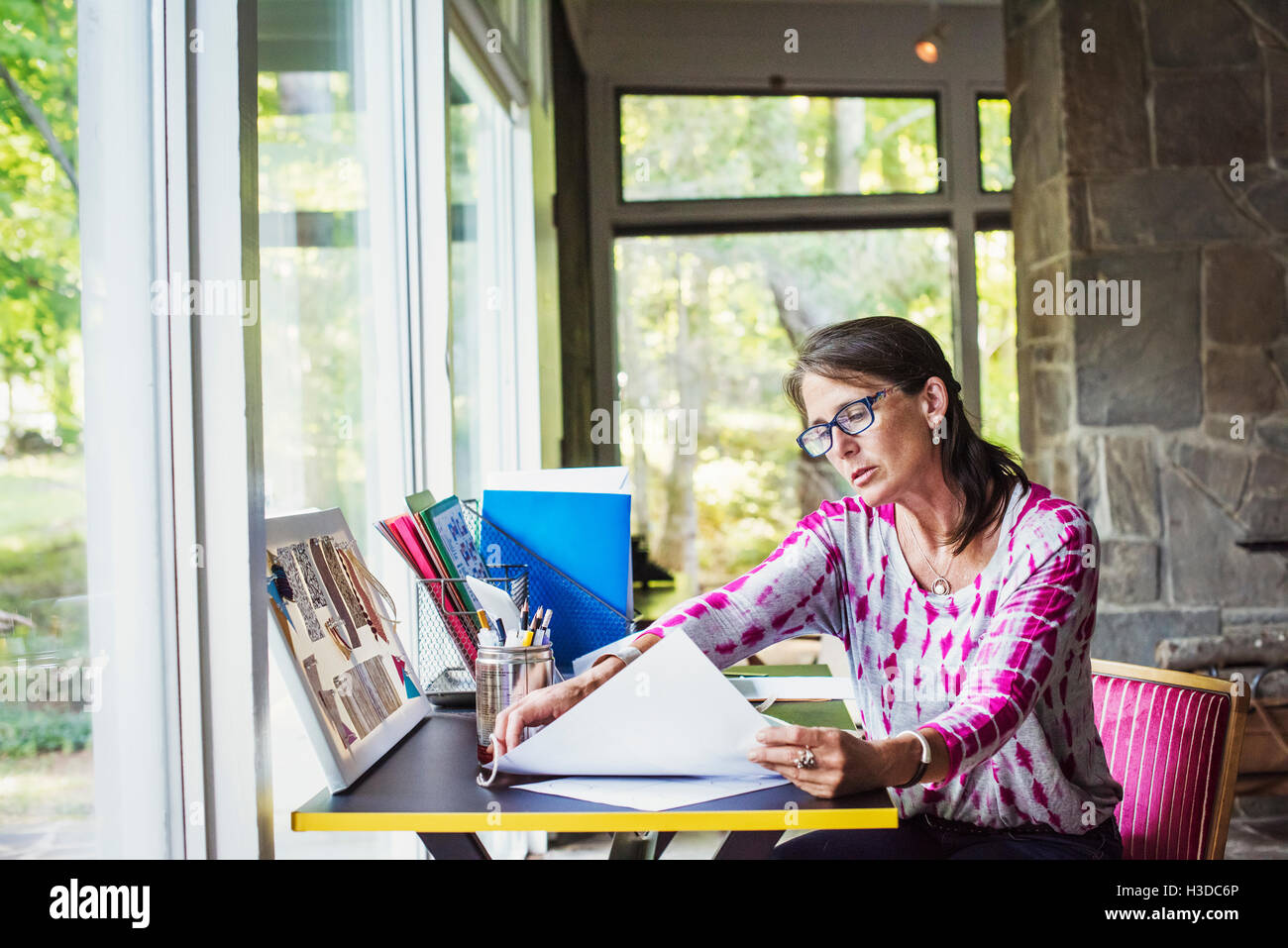Frau sitzt an einem Schreibtisch zu Hause, arbeiten. Stockfoto
