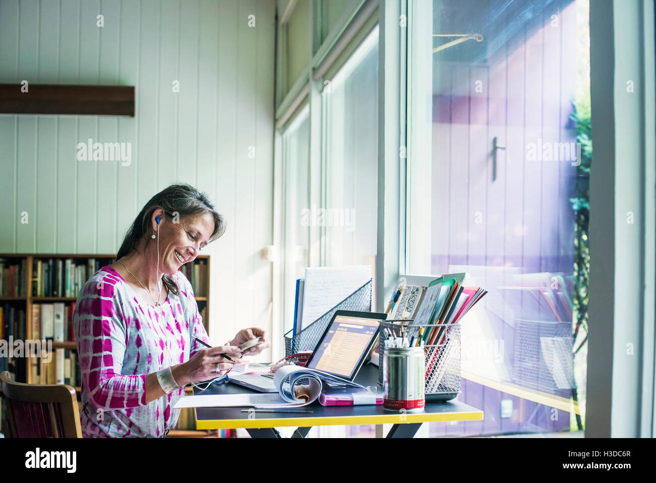 Frau sitzt an einem Schreibtisch zu Hause, arbeiten. Stockfoto