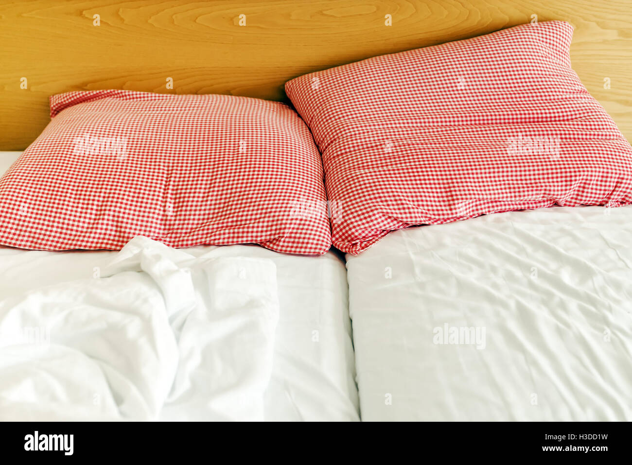 Drei-Sterne-Hotelbett und die Kissen mit zerknitterten Blätter am Morgen Stockfoto