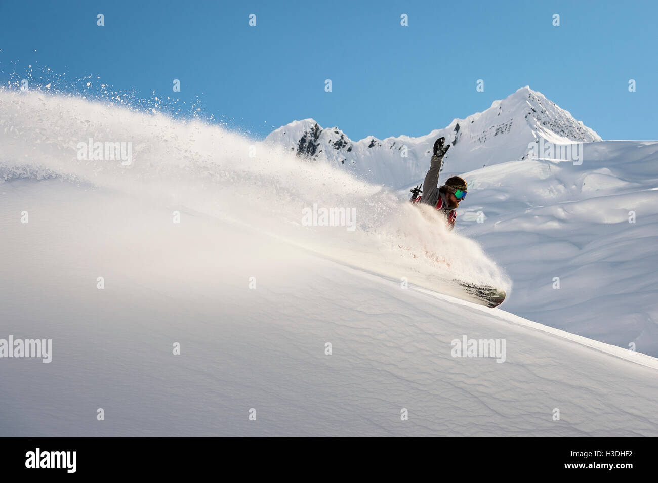 Snowboarder einen Schrägstrich im späten Nachmittag Licht auf einem Bergrücken im Backcountry zu tun Stockfoto