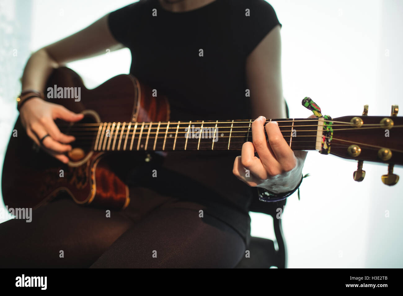 Frau spielt eine Gitarre in der Musikschule Stockfoto