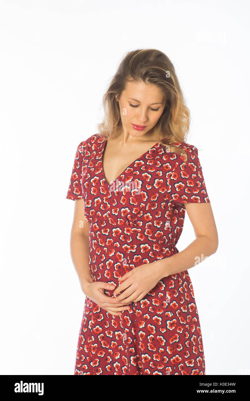 Schwangere junge Frau trägt ein rotes Kleid Hände auf Bauch Stockfotografie  - Alamy
