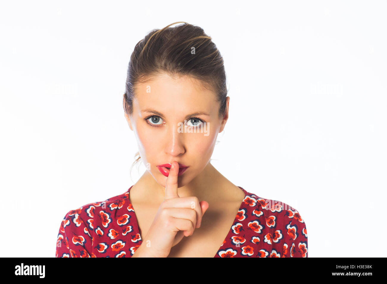Ernste junge Frau hand auf Mund als eine stille Geste Stockfoto