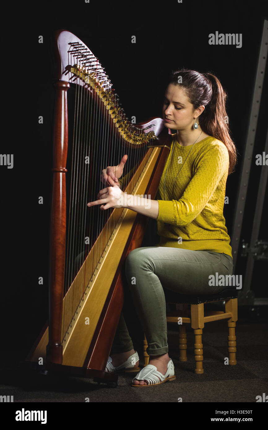 Frau spielt eine Harfe in der Musikschule Stockfoto
