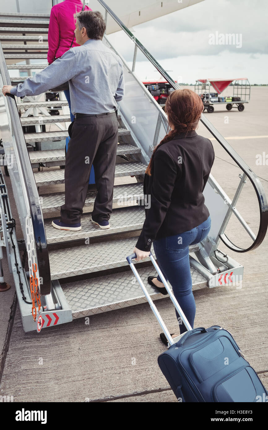 Passagiere auf der Treppe klettern und das Flugzeug betreten Stockfoto