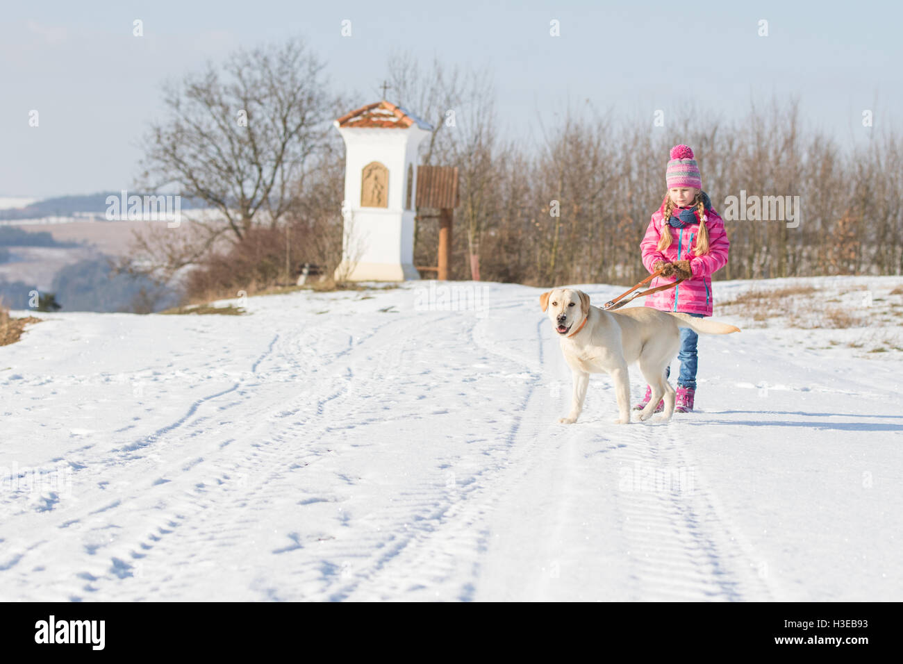Mädchen, die ihren Hund für einen Spaziergang an der Leine auf dem Lande auf einem sonnigen Tag n winter Stockfoto