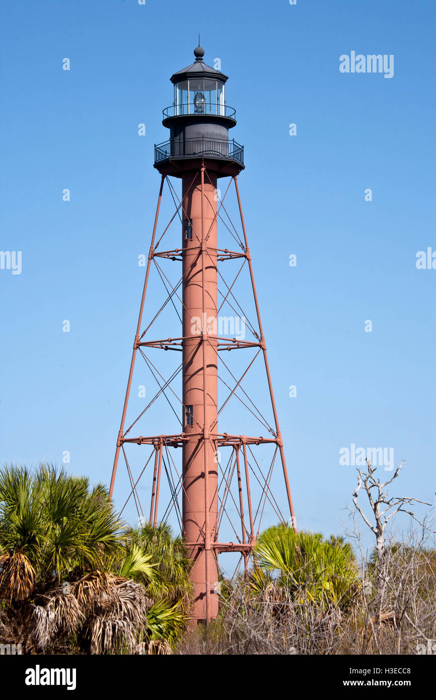 Die braune Skelettstruktur des historischen Anclote Leuchtturm kontrastiert gegen eine strukturlose blauen Himmel 110ft über Sabal Palmen. Stockfoto