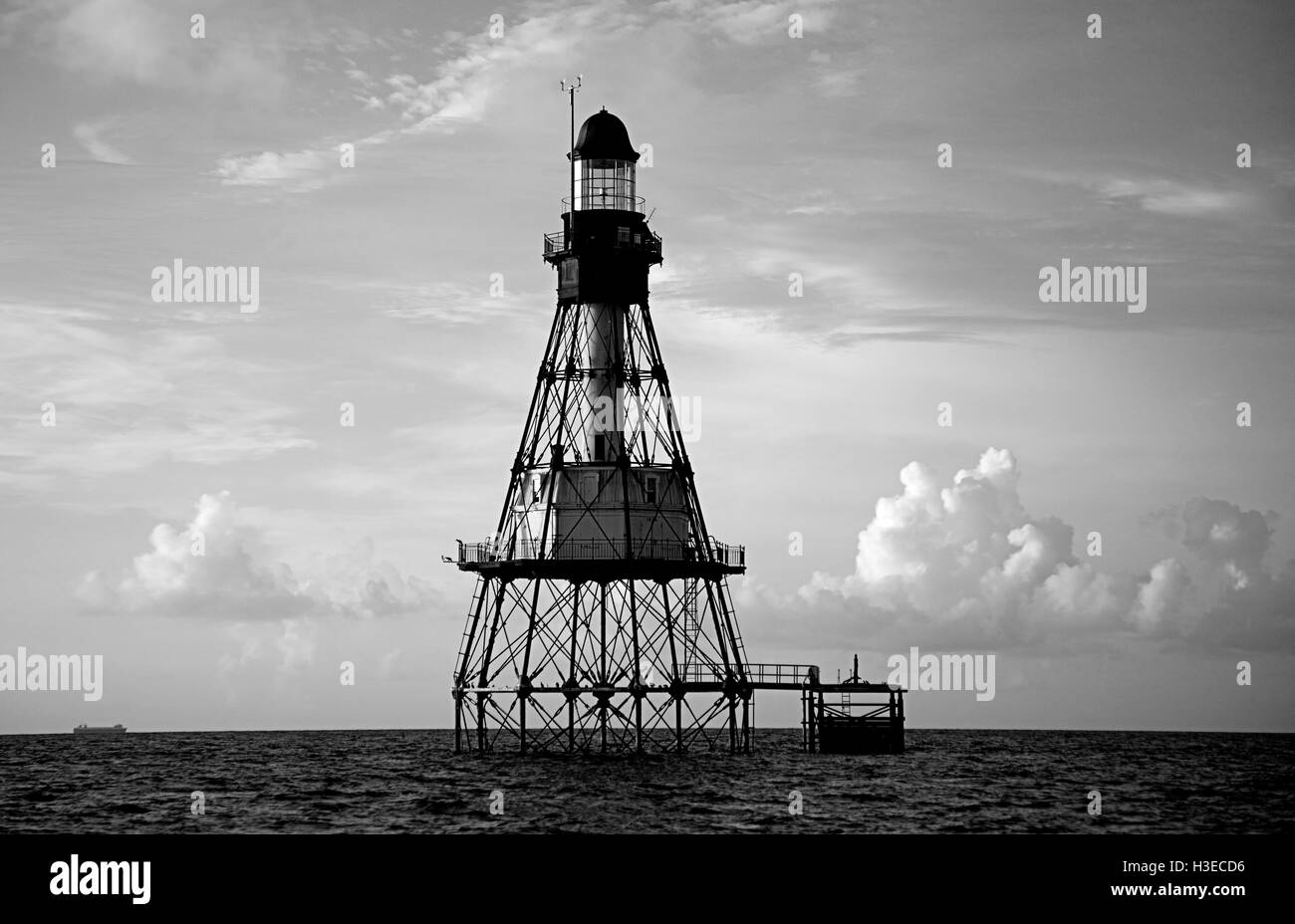 An einem heiteren ruhigen Morgen grüßt Floridas Fowey Felsen Leuchtturm das Licht des Tages in diesem schwarz / weiß Bild. Stockfoto
