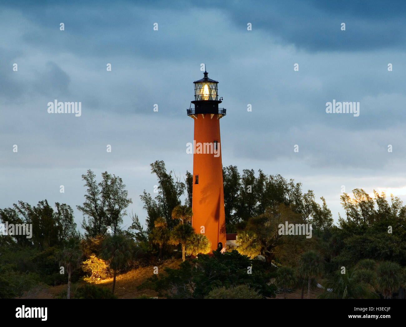 Der orange gemauerten Turm des Jupiter-Leuchtturm, Florida, scheint immer noch auf das Meer wie Sonnenaufgang an einem bewölkten Morgen kommt. Stockfoto