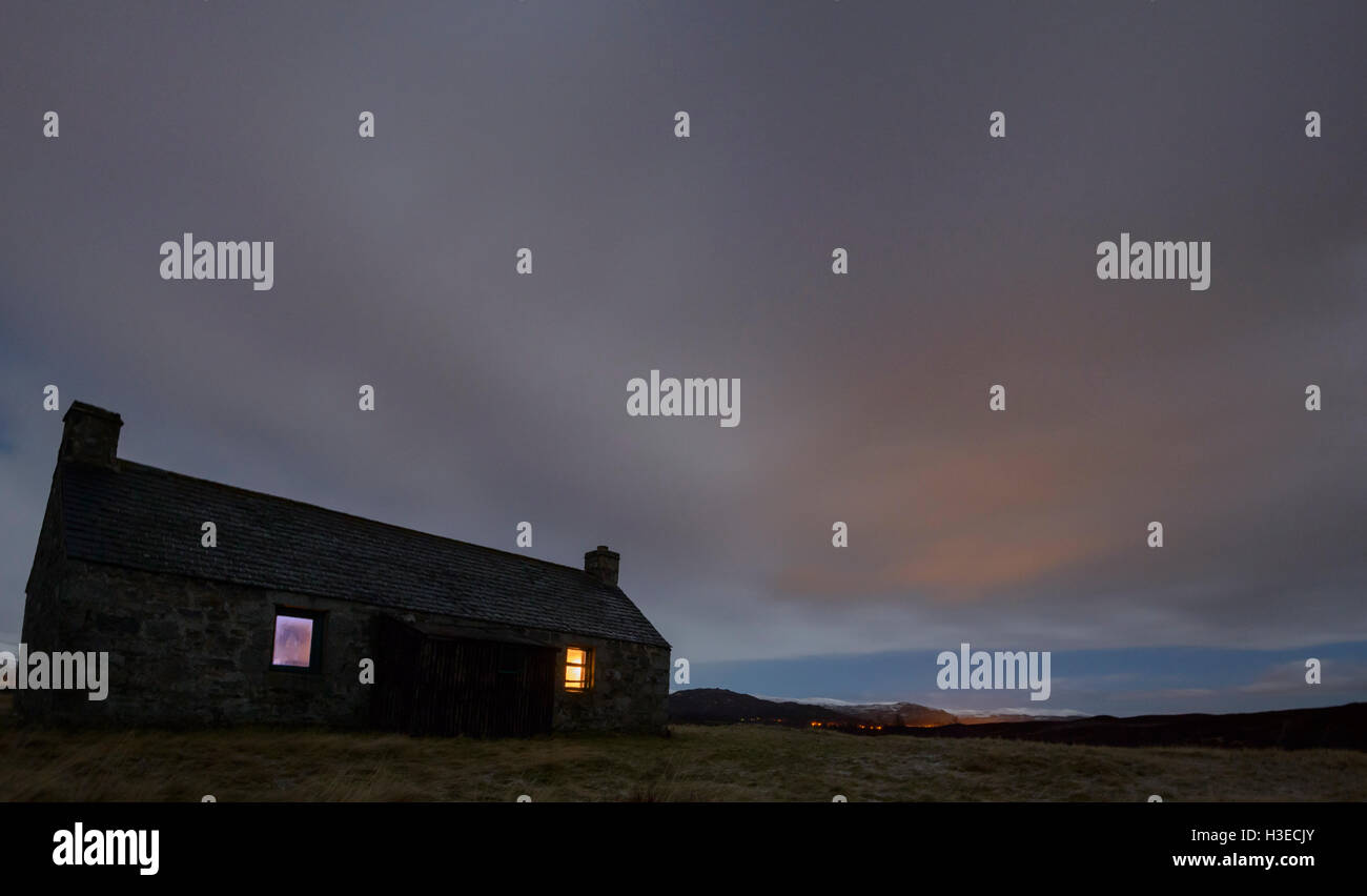 Luibleathann Bothy an einem kalten Januar-Nacht mit dem warmen Schein von offenem Feuer im Fenster Stockfoto