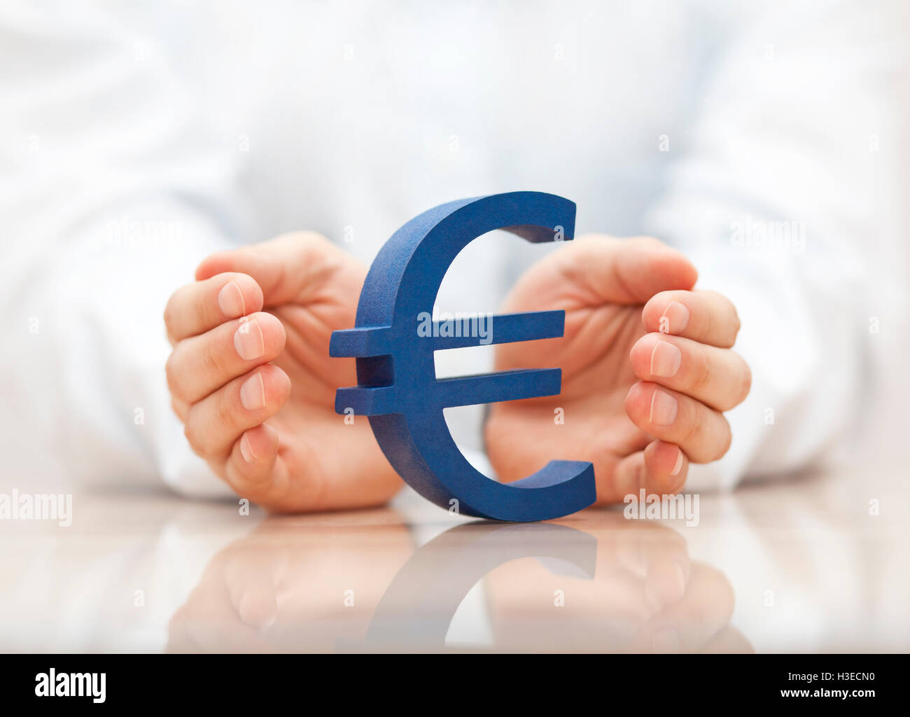Euro-Zeichen durch Hände geschützt Stockfoto