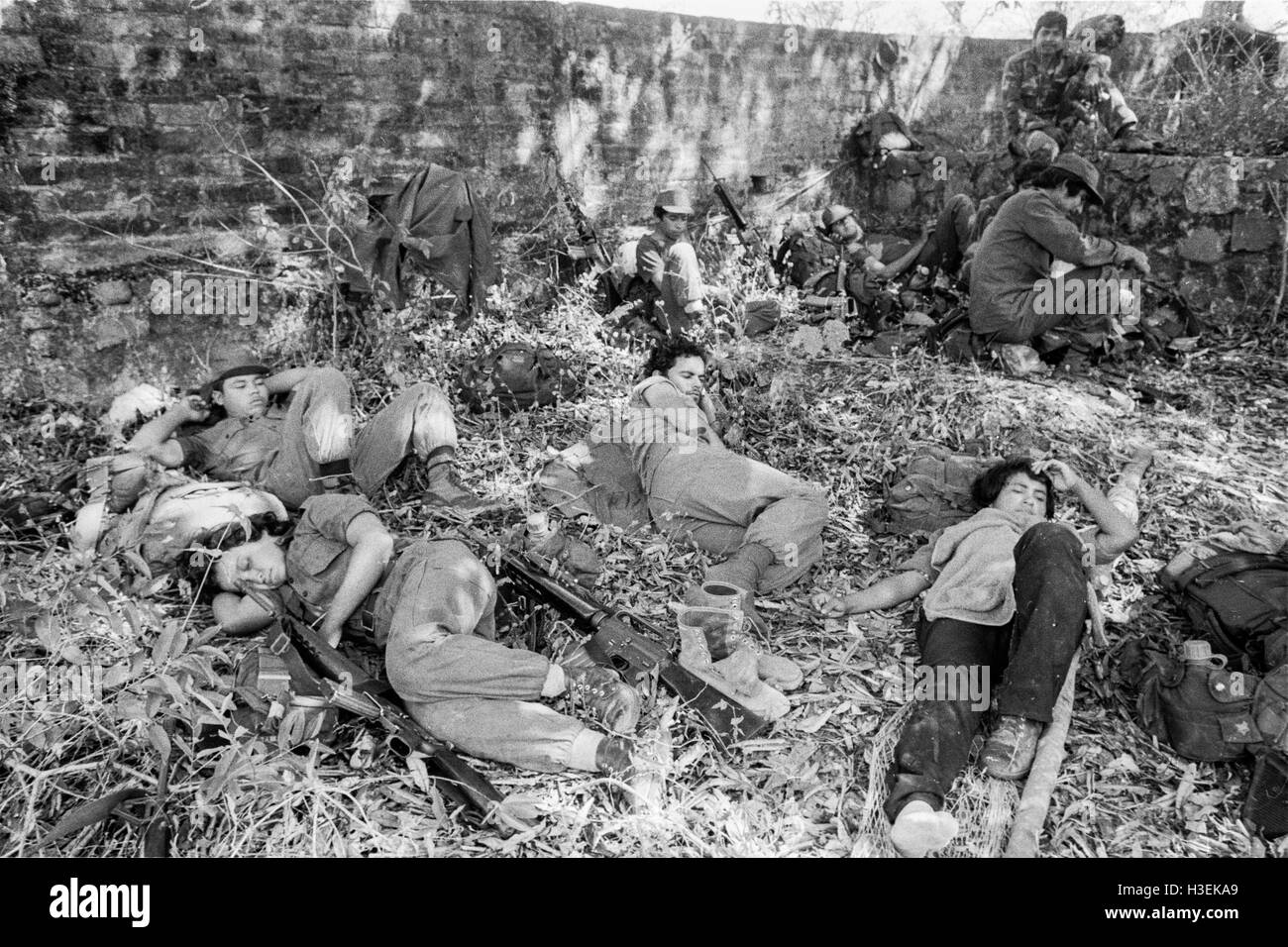 CHALATENANGO, EL SALVADOR, FEB 1984: - innerhalb der FPL Zonen Control A Guerillagruppe FPL-Männer und Frauen Kämpfer Rest und nehmen Wasser aus einem Stream. Stockfoto