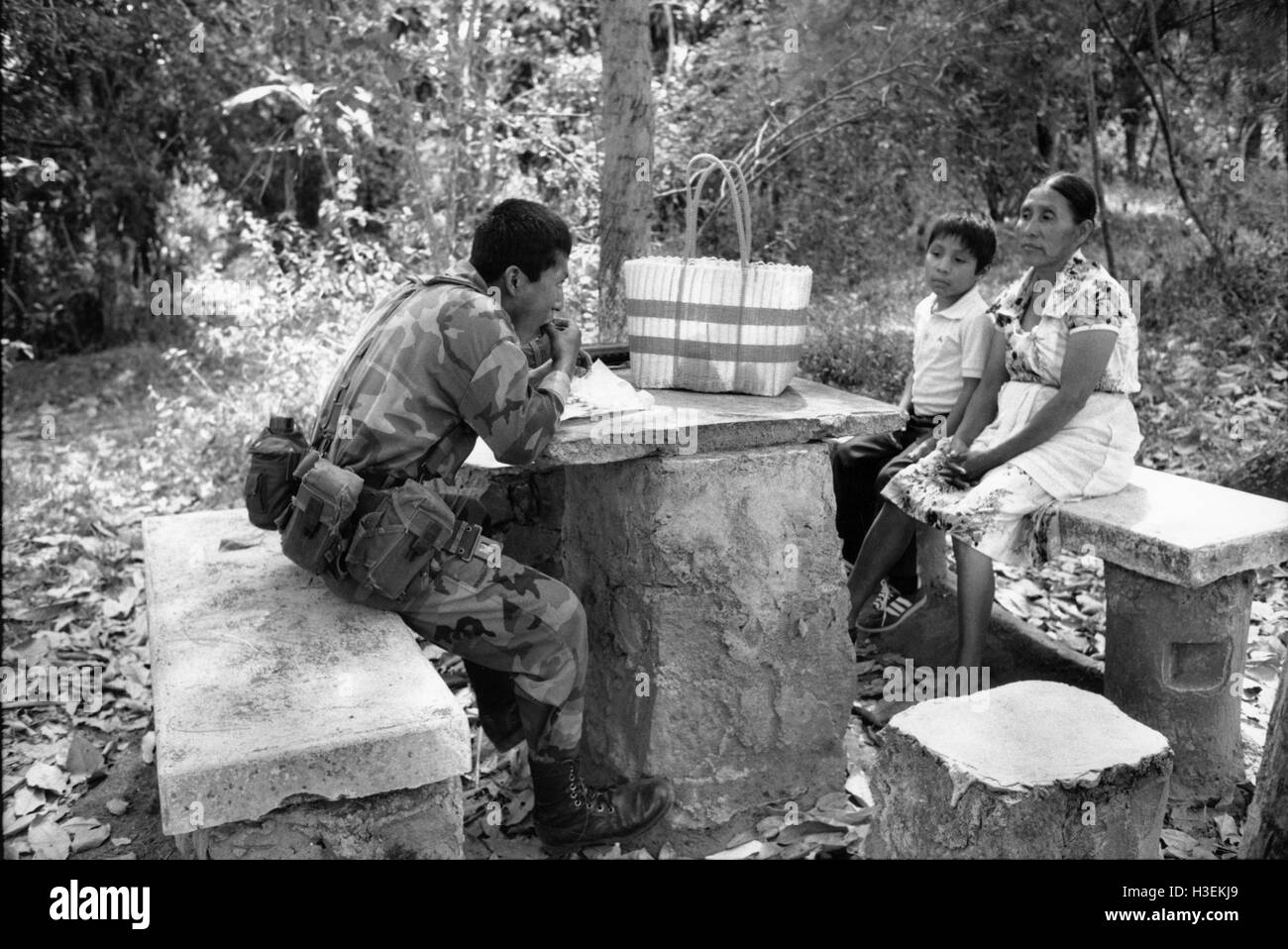 SAN SALVADOR, EL SALVADOR, FEB 1990 Mutter beobachtet ihren Sohn, ein Soldat in der Armee von Salvadorn, das Essen, die sie ihm bei einem Besuch in seiner Kaserne gebracht hat. Stockfoto