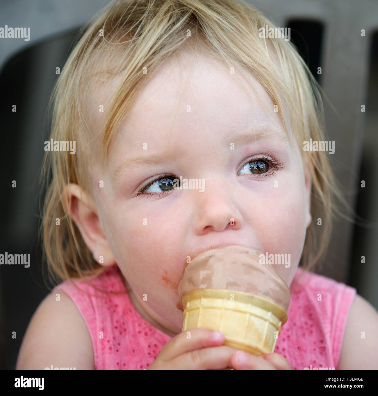 Ein kleines Mädchen (2 Jahre alt) Essen ein Eis Stockfoto