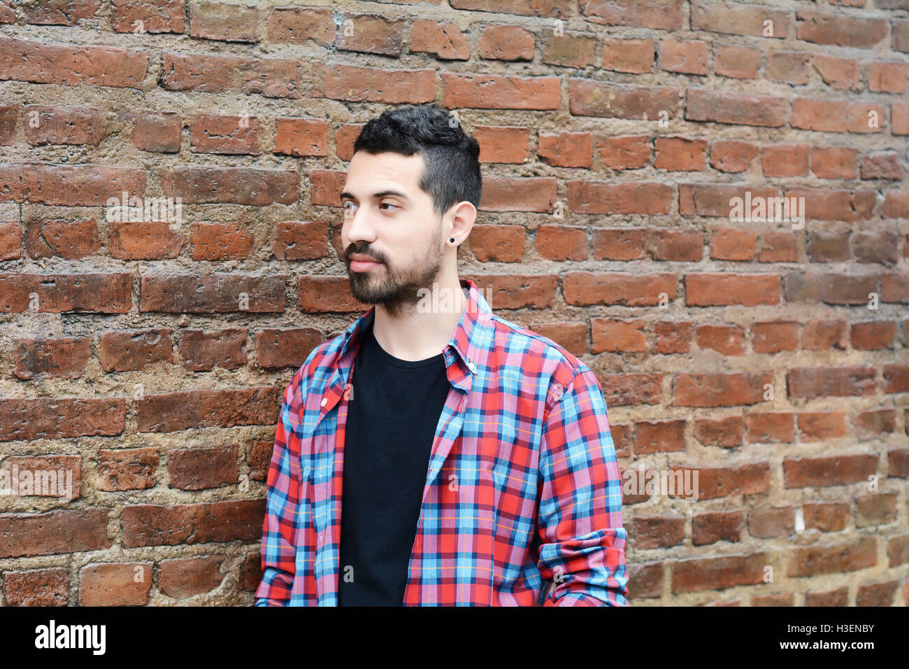 Porträt eines jungen Mannes der lateinischen gegen Mauer. Im Freien. Städtebauliche Konzept. Stockfoto