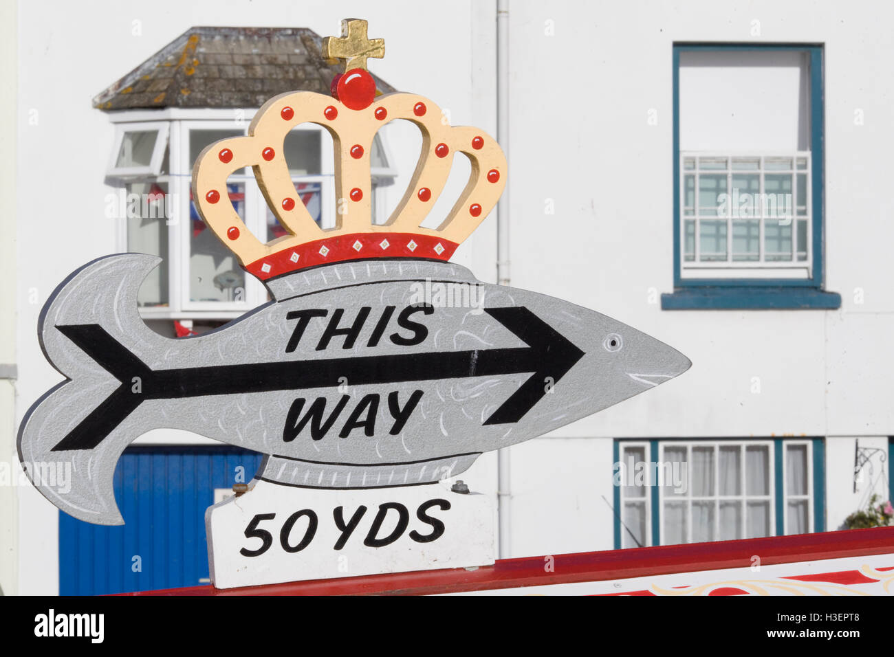 Holz schneiden Sie Fisch mit einer Krone auf Pfeil weist uns den Weg zu einem Fish &amp; Chips-shop Stockfoto