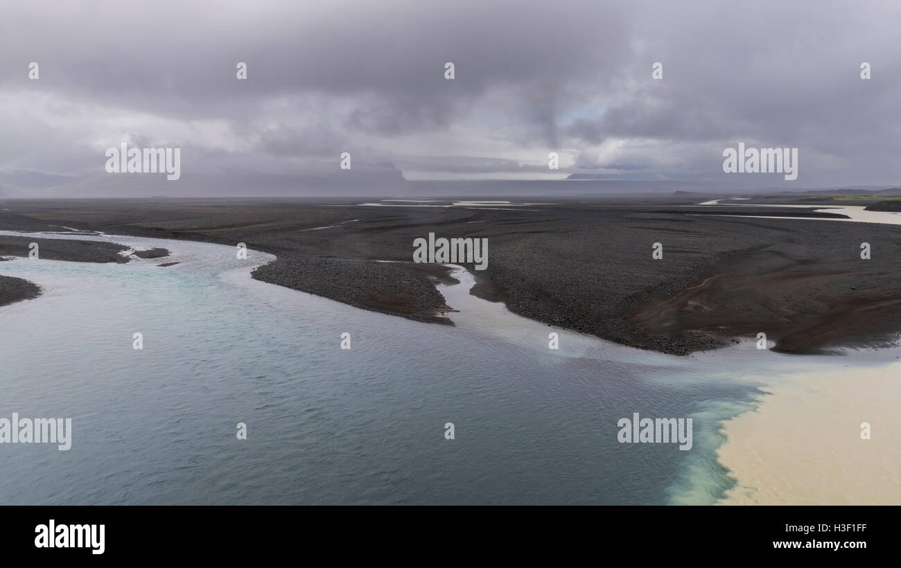 Fluss Nupsvotn mit großen Lavasand-Feldern in der Nähe von Kalfafell mit dunklen Wolken auf Island. Stockfoto