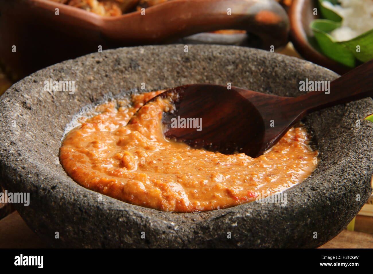 Sambal Kacang, pikanter Erdnuss-Sauce, Gericht in Nasi Uduk Betawi. Platziert in einem Steinzeug Mörser. Stockfoto