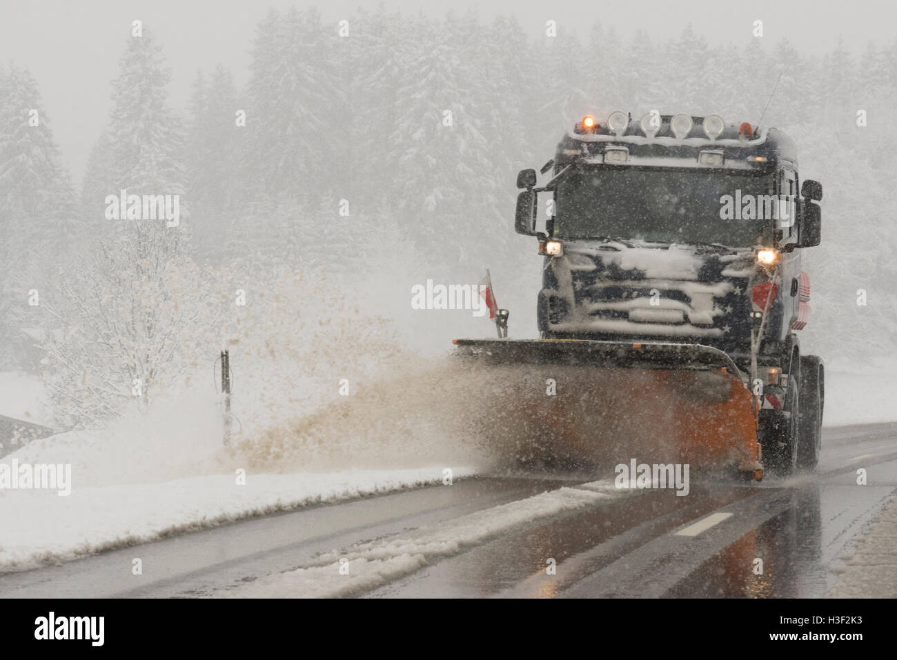 LKW entfernt Straße in Deutschland bei schlechtem Winterwetter Schnee. Stockfoto