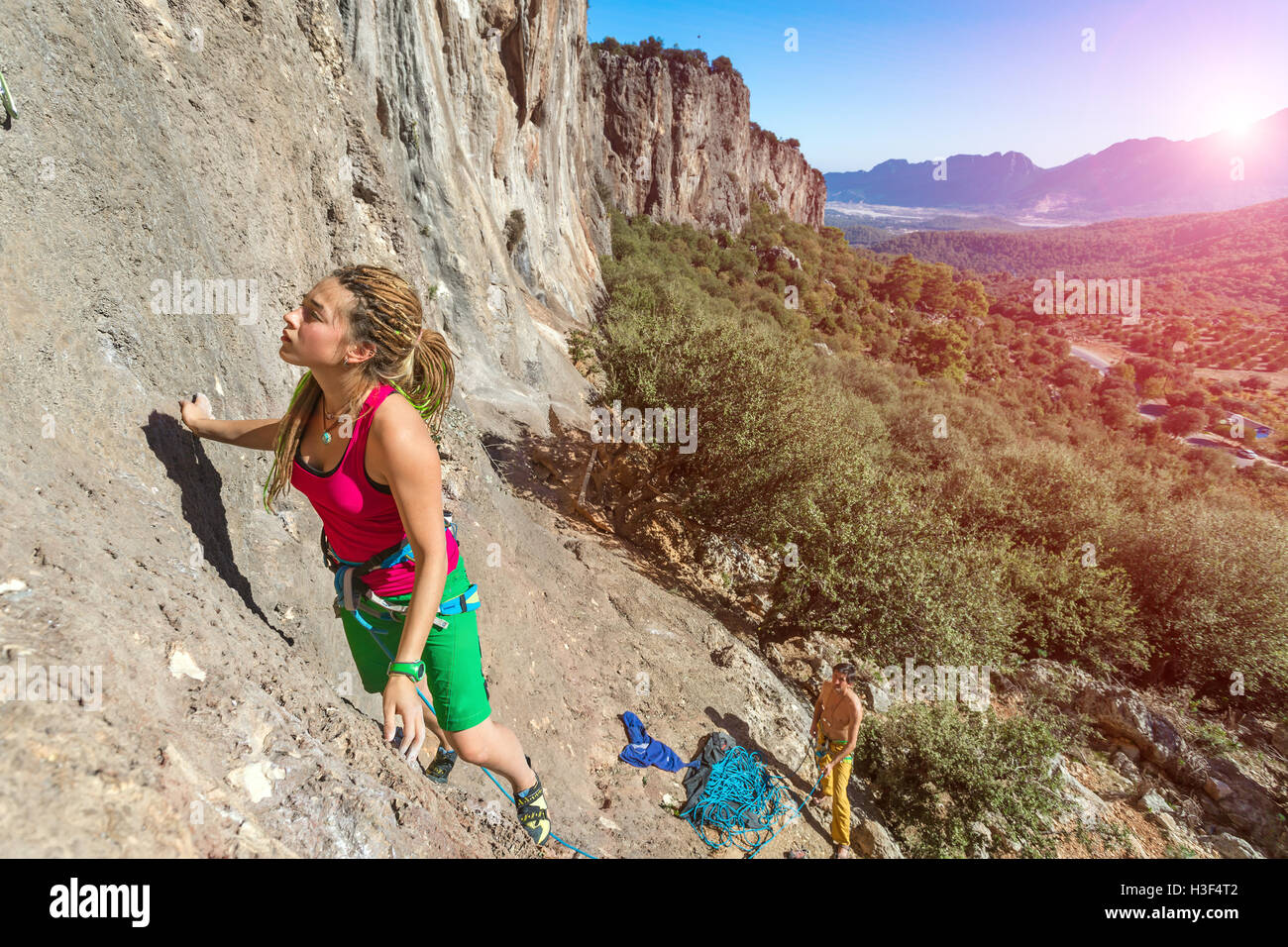 Junge talentierte weibliche Kletterer, die aufsteigenden Felswand Stockfoto