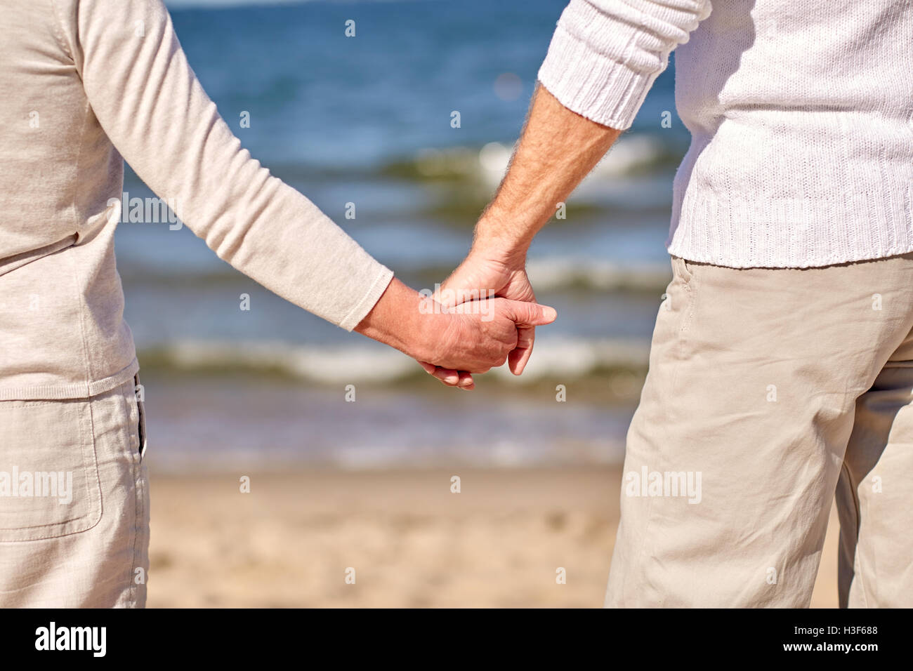 Nahaufnahme eines älteres paar Hand in Hand am Strand Stockfoto