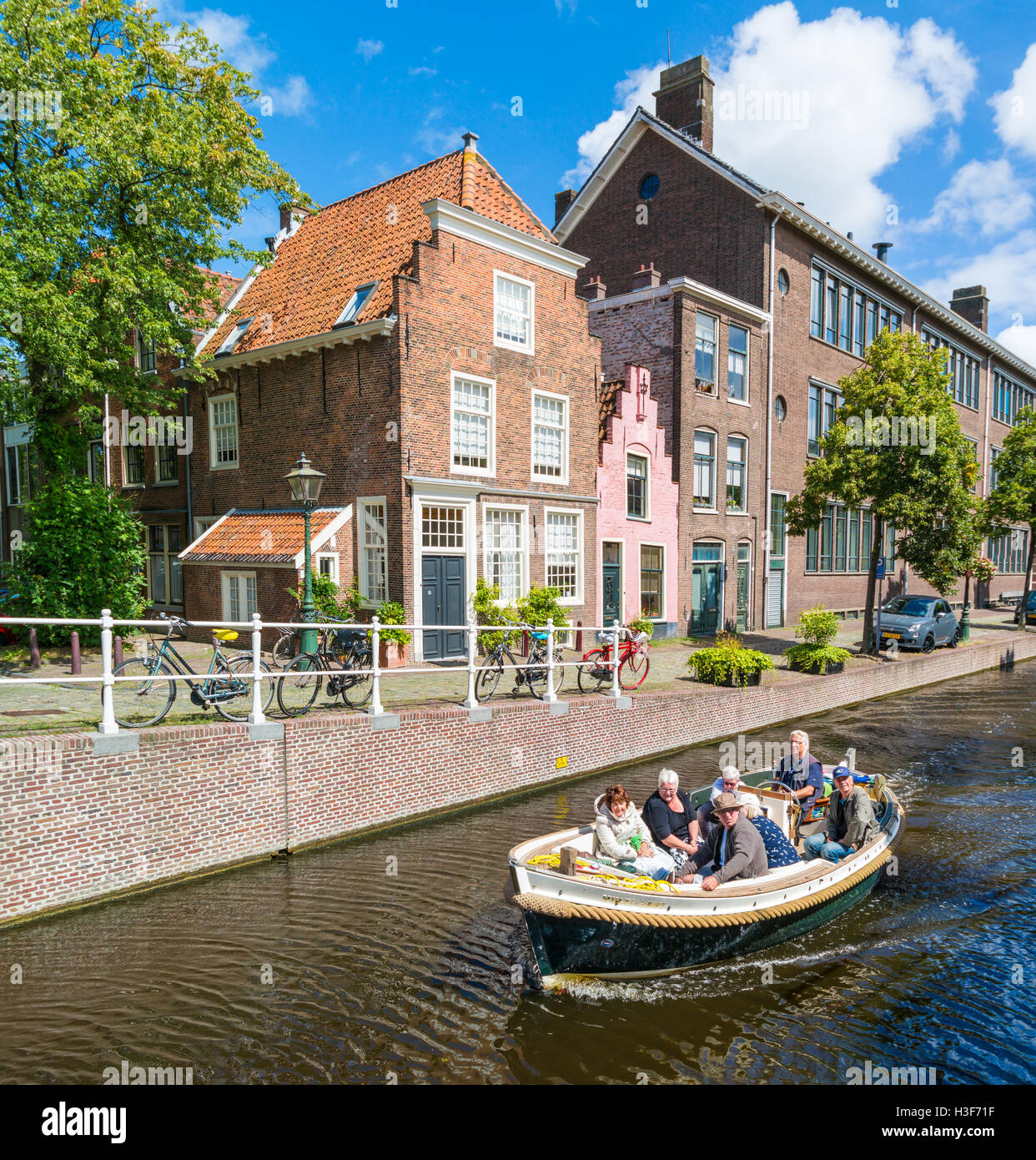 Lastkahn Tour mit Menschen am Groenhazengracht-Kanal in der Innenstadt von Leiden, Südholland, Niederlande Stockfoto