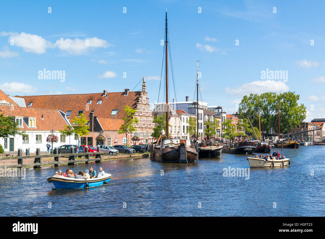 Menschen in Bargen auf Grachtenfahrt und City wharf Stadstimmerwerf am Galgewater-Kanal in Leiden, Südholland, Niederlande Stockfoto