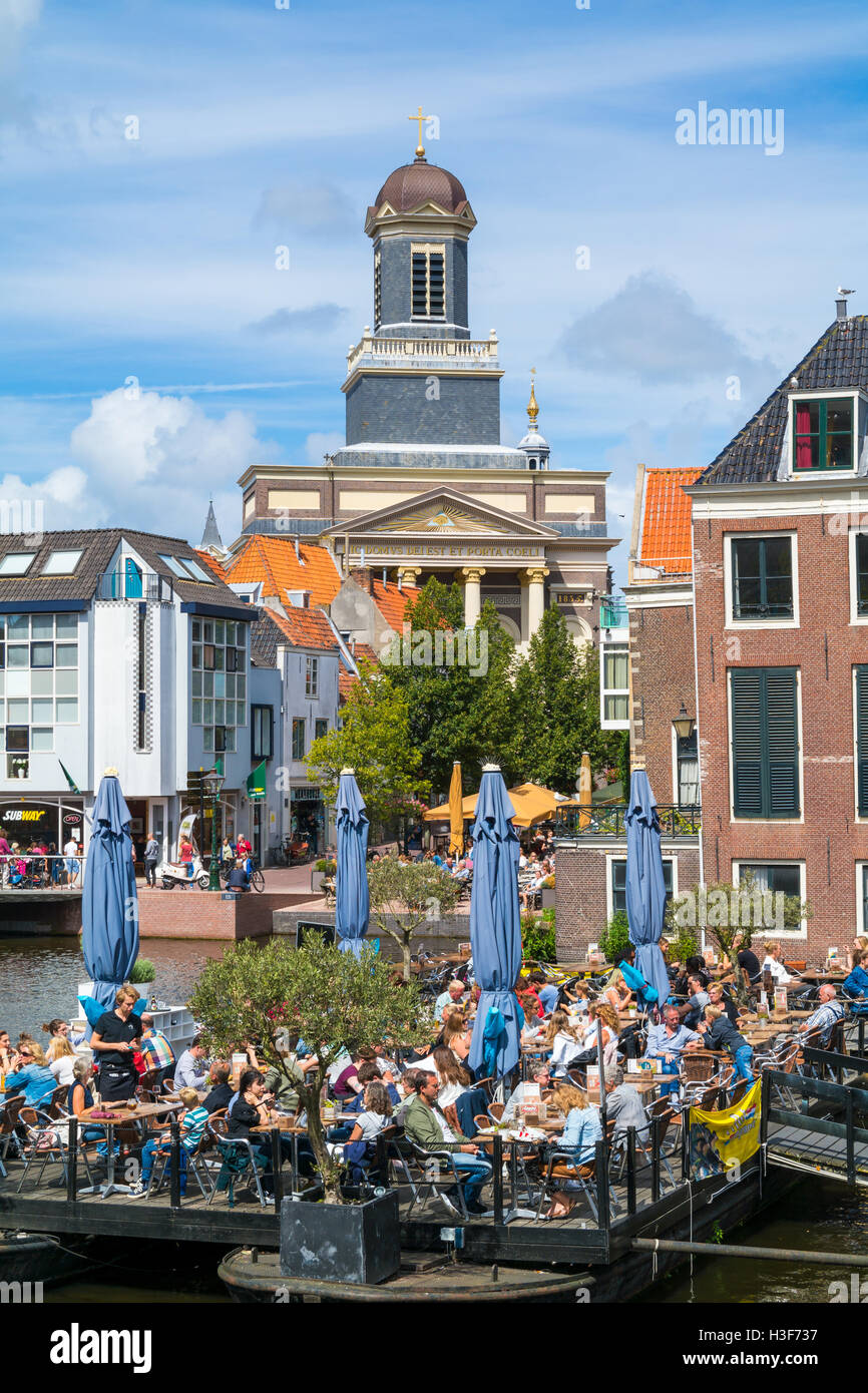 Hartebrugkerk Kirchturm und Menschen auf der Terrasse des Cafés am Rhein-Kanal in Leiden, Südholland, Niederlande Stockfoto