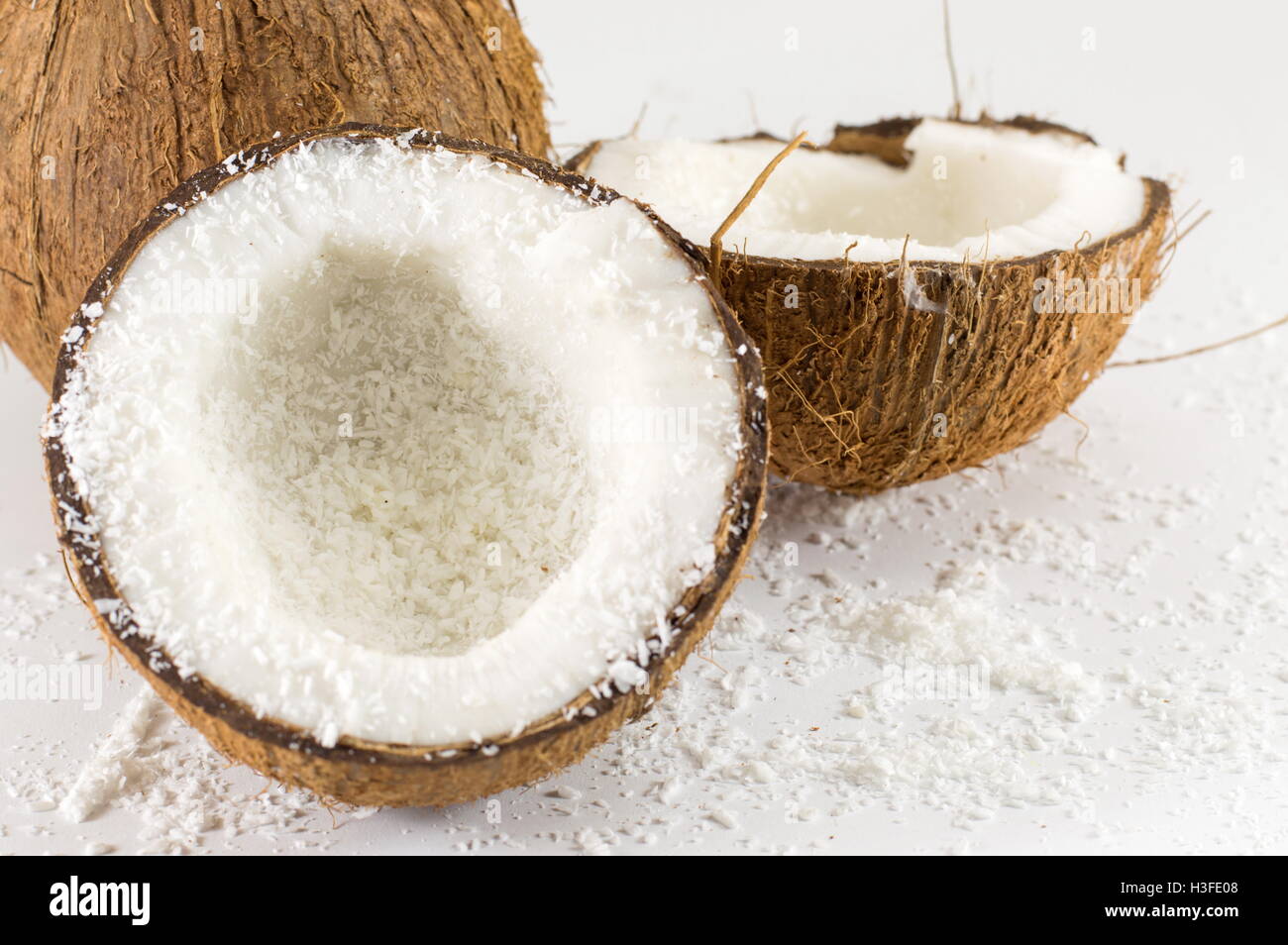 Halbierte frische Kokosnuss und Pulver auf dem Tisch Stockfoto