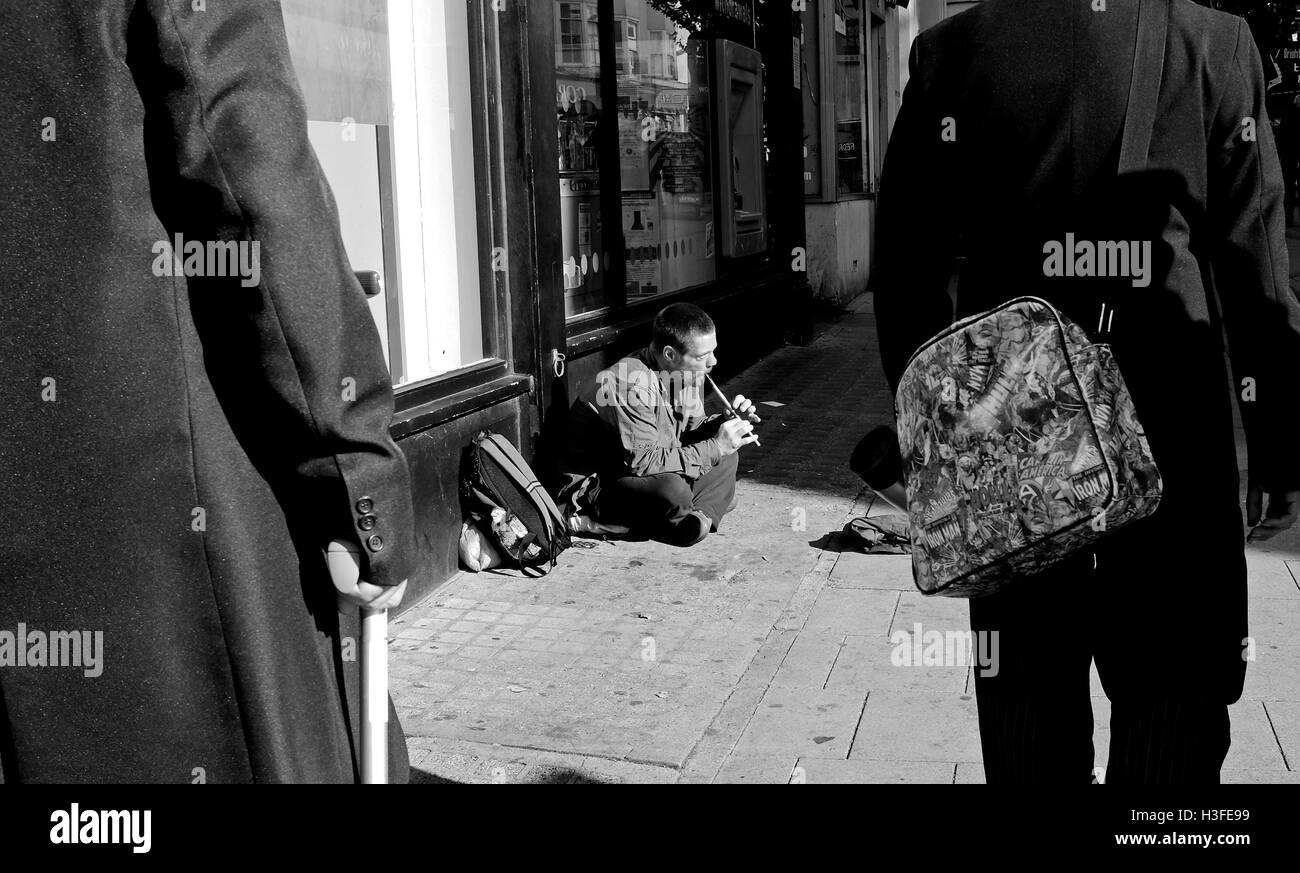 Armut auf den Straßen von Brighton als Bettler spielt Penny Whistle für Geld Stockfoto