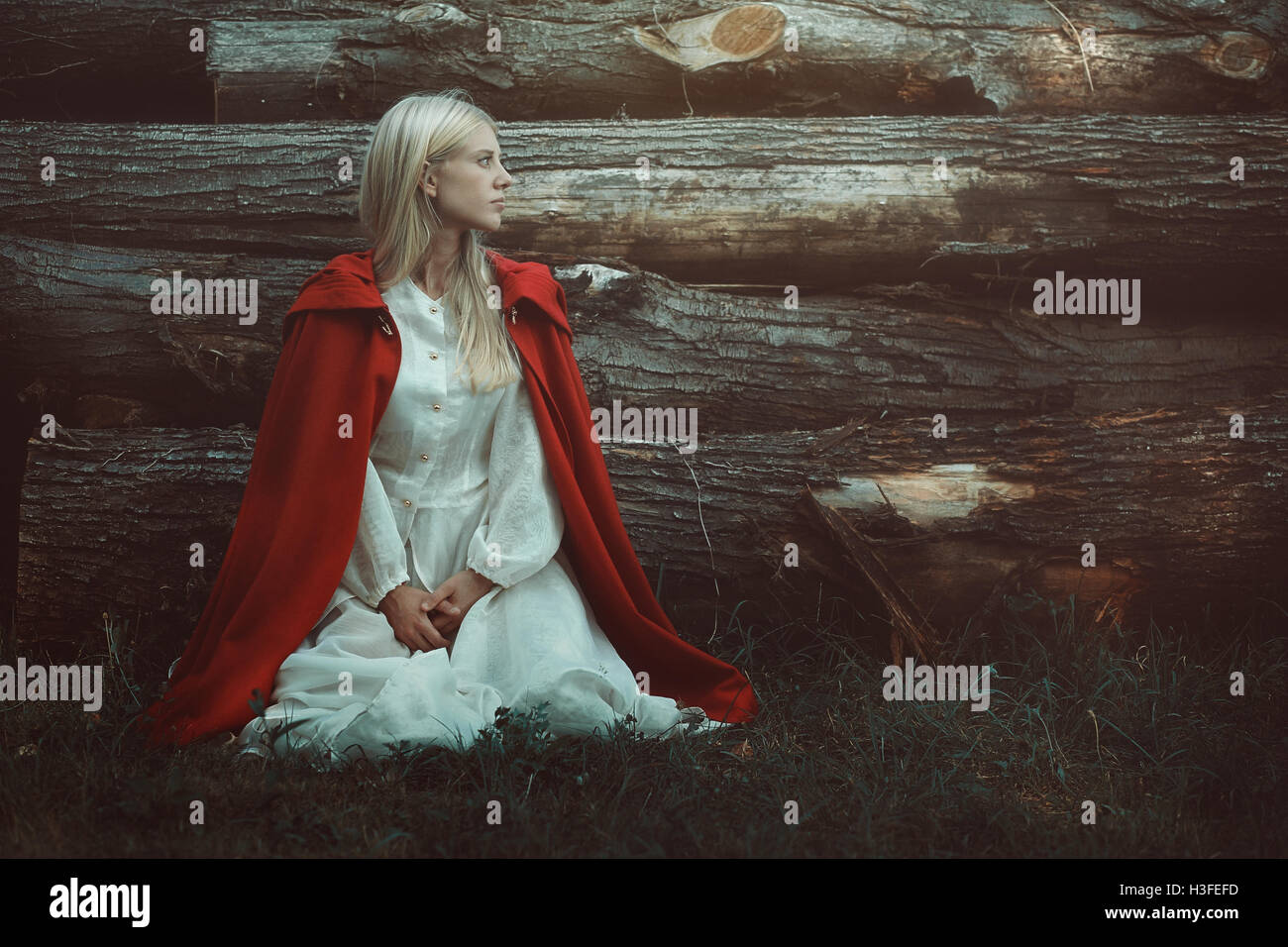 Blonde Frau mit rotem Mantel mit Kapuze. Porträtgemälde Stockfoto